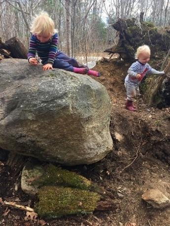 Two children sitting on a rock
Description automatically generated with low confidence