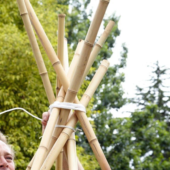 This may contain: a man is holding up some bamboo sticks