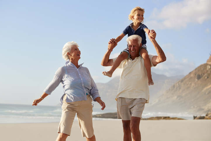 Grandparents Carrying Grandson On Shoulders On Walk Along Beach - Affinity  Asset Management