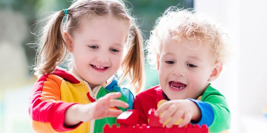 block activities for toddlers and preschoolers-block play-two toddlers playing with colorful blocks