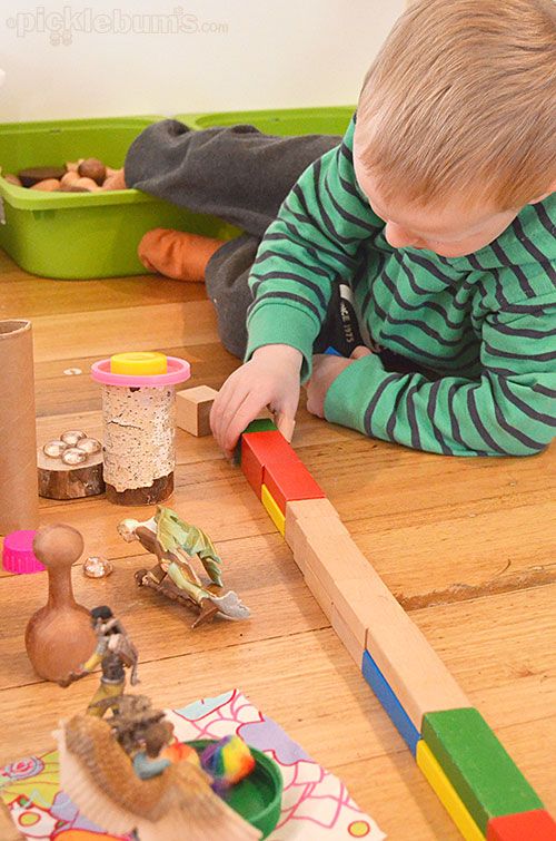 This may contain: a young boy playing with toys on the floor