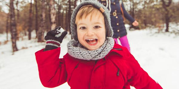 Young boy throwing a snow ball outside