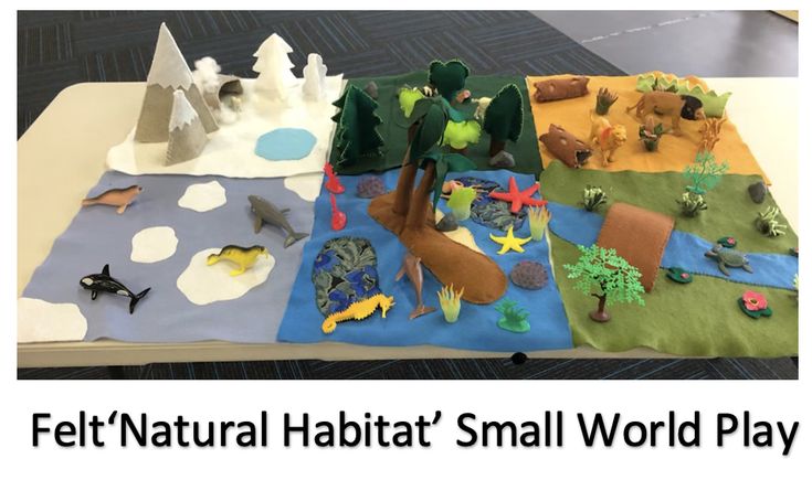 This may contain: a table topped with lots of different types of felt animals and trees on top of it