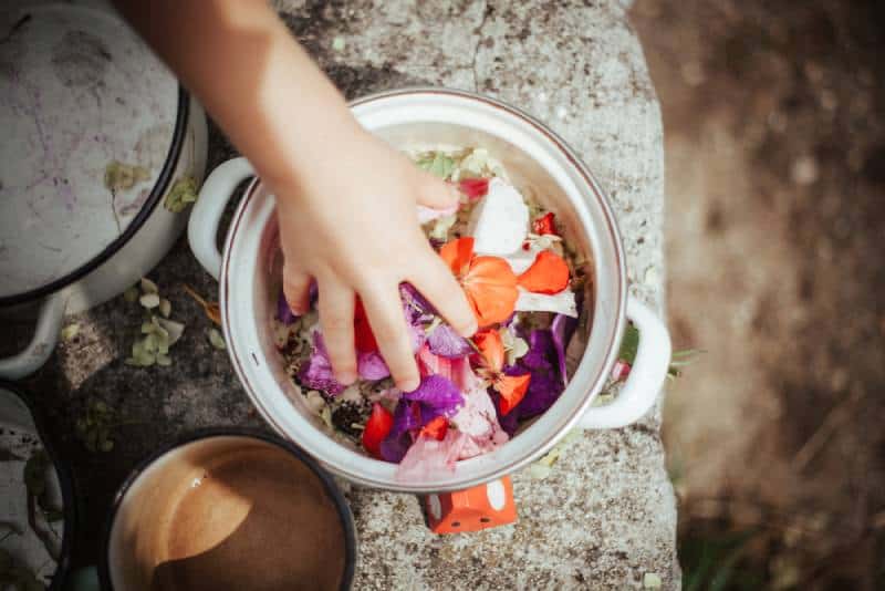 Kids playing in the garden, cooking flowers soup