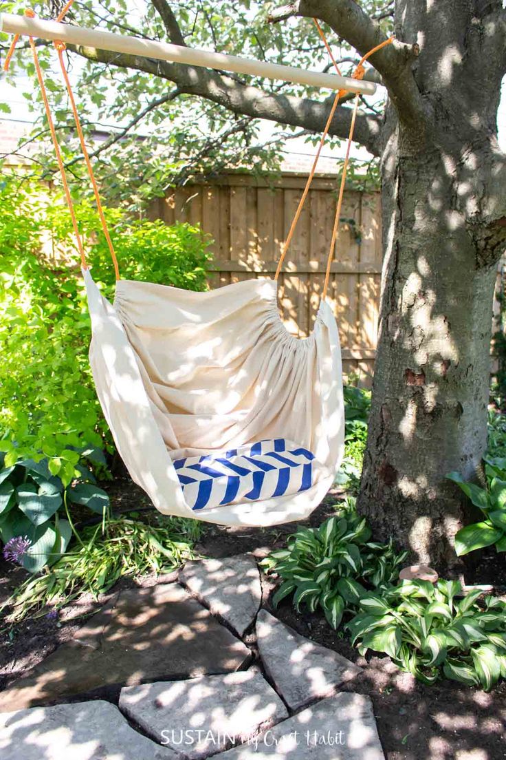 This may contain: a white and blue hammock hanging from a tree