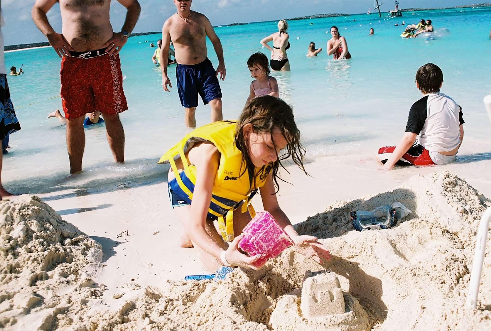 A group of people playing in the sand at the beach

Description automatically generated