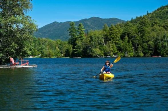 Woman kayaking on Mirror Lake in Lake Placid