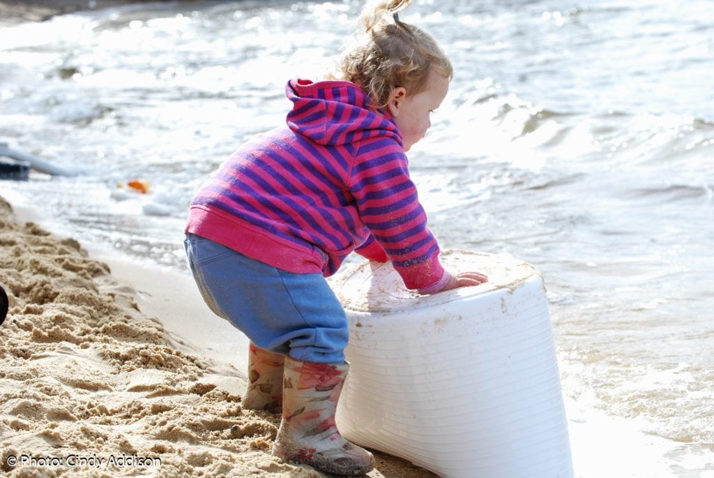 a child playing with a white box on a beach