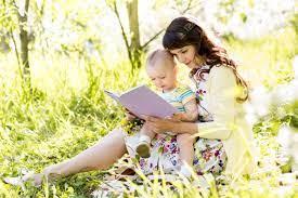 A person and a baby looking at a computer in a grassy area

Description automatically generated with low confidence