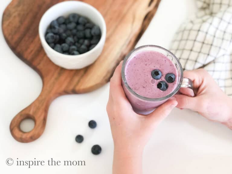 blueberry vanilla kefir smoothie recipe. holding smoothie. www.inspirethemom.com