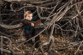 A child sitting in a pile of sticks
Description automatically generated with low confidence