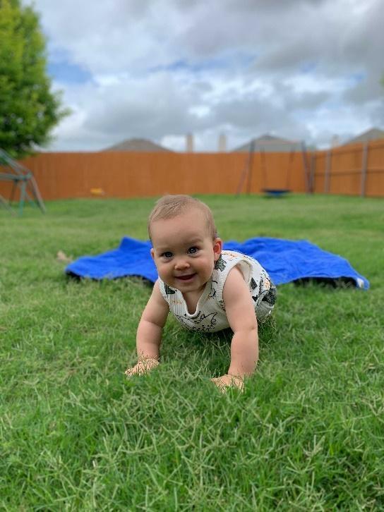A baby lying in the grass

Description automatically generated with medium confidence