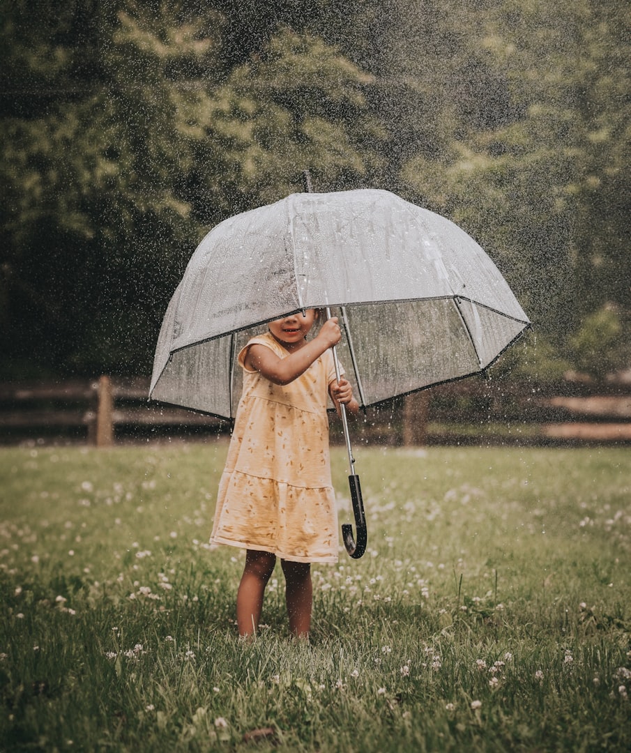 kid dancing in rain puddle barefoot outdoor rainy day activity with quote (by Nell Regan K, photo of C. Kartychok)